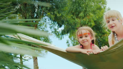 Funny-Children-With-Painted-Faces-Ride-On-A-Hammock-On-The-Territory-Of-The-Hotel-On-The-Beach