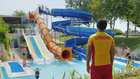 Rear-View---The-Rescuer-Watches-People-On-The-Water-Slides-Working-In-The-Water-Park