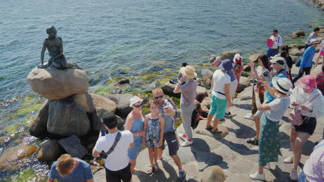 A-Crowd-Of-Tourists-Is-Photographed-Near-The-Famous-Statue-Of-The-Little-Mermaid-In-Copenhagen