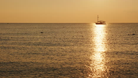 Fischerboot-Im-Meer-Bei-Sonnenaufgang-Eine-Schöne-Silhouette-In-Einem-Glänzenden-Weg-Auf-Dem-Wasser-4k-Video