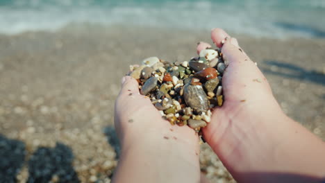 Female-Hands-Hold-A-Handful-Of-Wet-Pebbles-Rest-On-The-Sea-Meditación-Concept-4k-Video