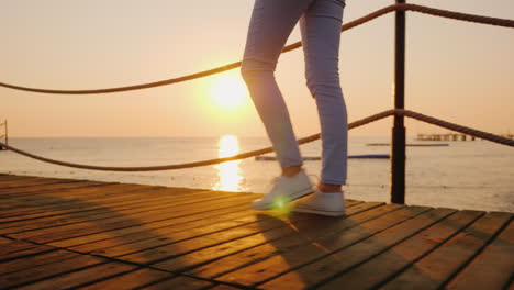 Morning-Jog-On-The-Pier-When-The-Sun-Rises-Over-The-Sea-In-The-Frame-Only-The-Legs-Are-Visible-Stead