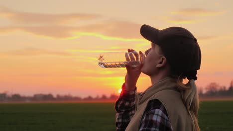 Tired-Farmer-Woman-Drinking-Clean-Water-From-Bottle-At-Sunset