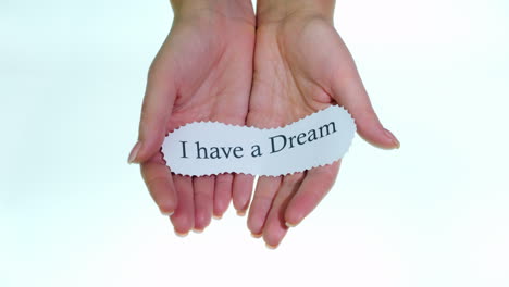 Note-I-Have-A-Dream-In-Female-Hands-On-A-White-Background