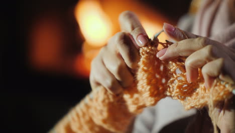 Abend-Am-Kamin-Vor-Weihnachten---Eine-Frau-Strickt-Warme-Kleidung-4k-Video