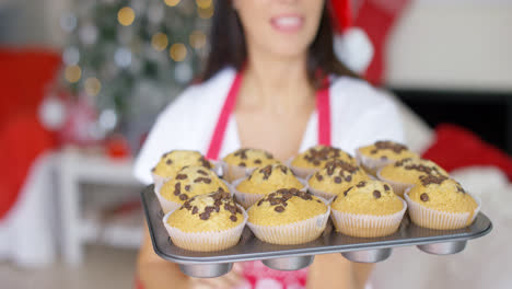 Young-woman-with-a-tray-of-Christmas-cupcakes