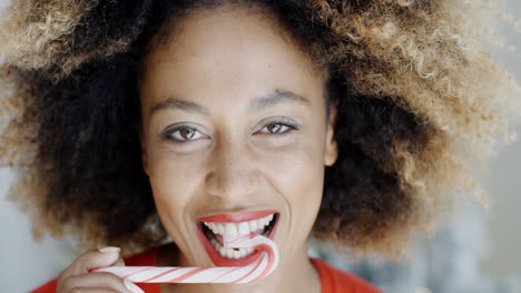 Young-woman-biting-a-festive-candy-cane