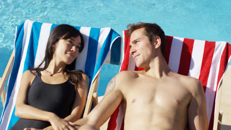 Contented-young-couple-smiling-as-they-sunbathe
