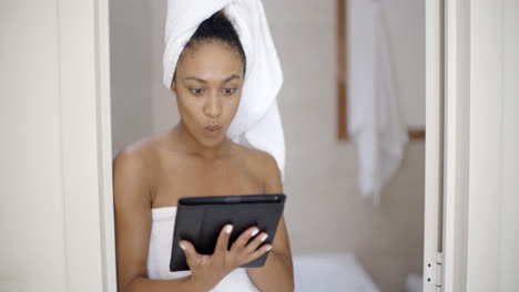 Young-Woman-Wearing-Bath-Towel-Using-Tablet-Computer