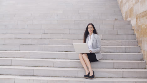 Business-woman-with-laptop-on-stairs