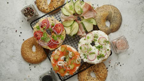 Delicious-Bagel-sandwiches-with-creamy-cheese--ham--hummus--salmon-and-vegetables
