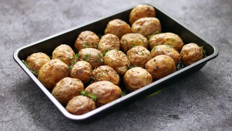 Homemade-roasted-whole-potatoes-in-jackets--With-butter--rosemary-and-thyme--Served-in-metallic-dish