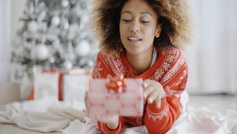 Thoughtful-young-woman-with-a-Christmas-gift