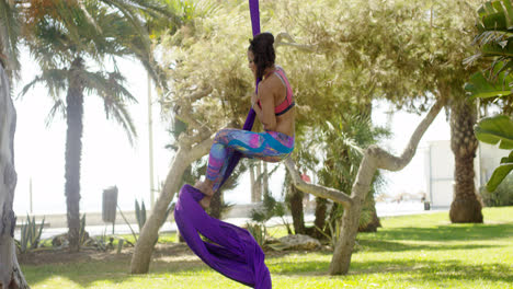 Female-acrobat-working-outdoors-on-silk-ribbons