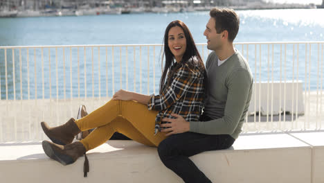 Loving-young-couple-relaxing-at-the-waterfront
