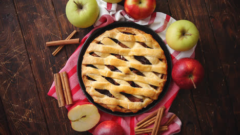 Homemade-pastry-apple-pie-with-bakery-products-on-dark-wooden-kitchen-table