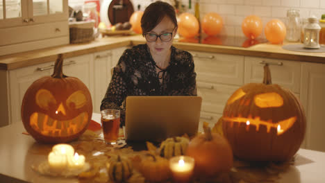 Frau-Mit-Laptop-Inmitten-Von-Halloween-Dekorationen
