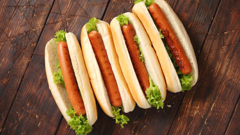 Tasty-american-hot-dogs-assorted-in-row--Placed-on-wooden-table
