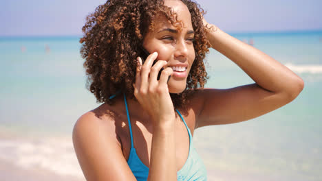 Mujer-Riendo-Hablando-Por-Teléfono-En-La-Playa