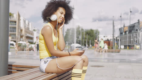 Model-in-headphones-sitting-on-bench