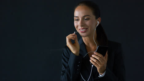 Businesswoman-talking-on-smartphone-with-earphones