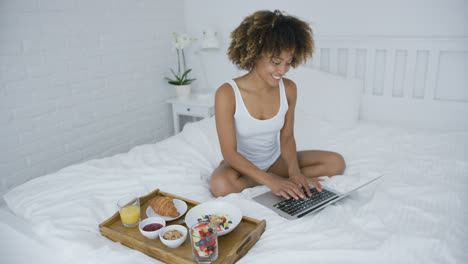 Content-woman-with-laptop-and-breakfast-