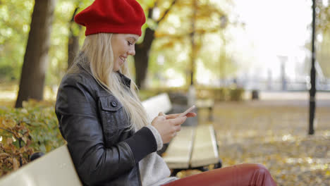Happy-looking-woman-in-beret-using-smartphone