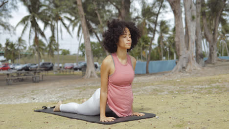 Confident-black-woman-stretching-on-mat