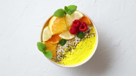 Tasty-orange-fresh-smoothie-or-yogurt-served-in-bowl--With-raspberries--orange-slices--chia-seeds
