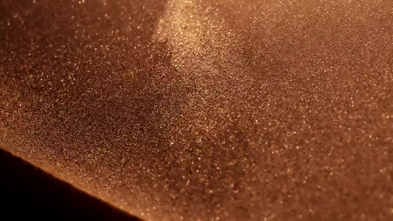 Particelle di sabbia dorate che cadono in slow motion