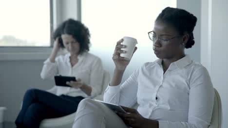serious businesswomen with digital tablets