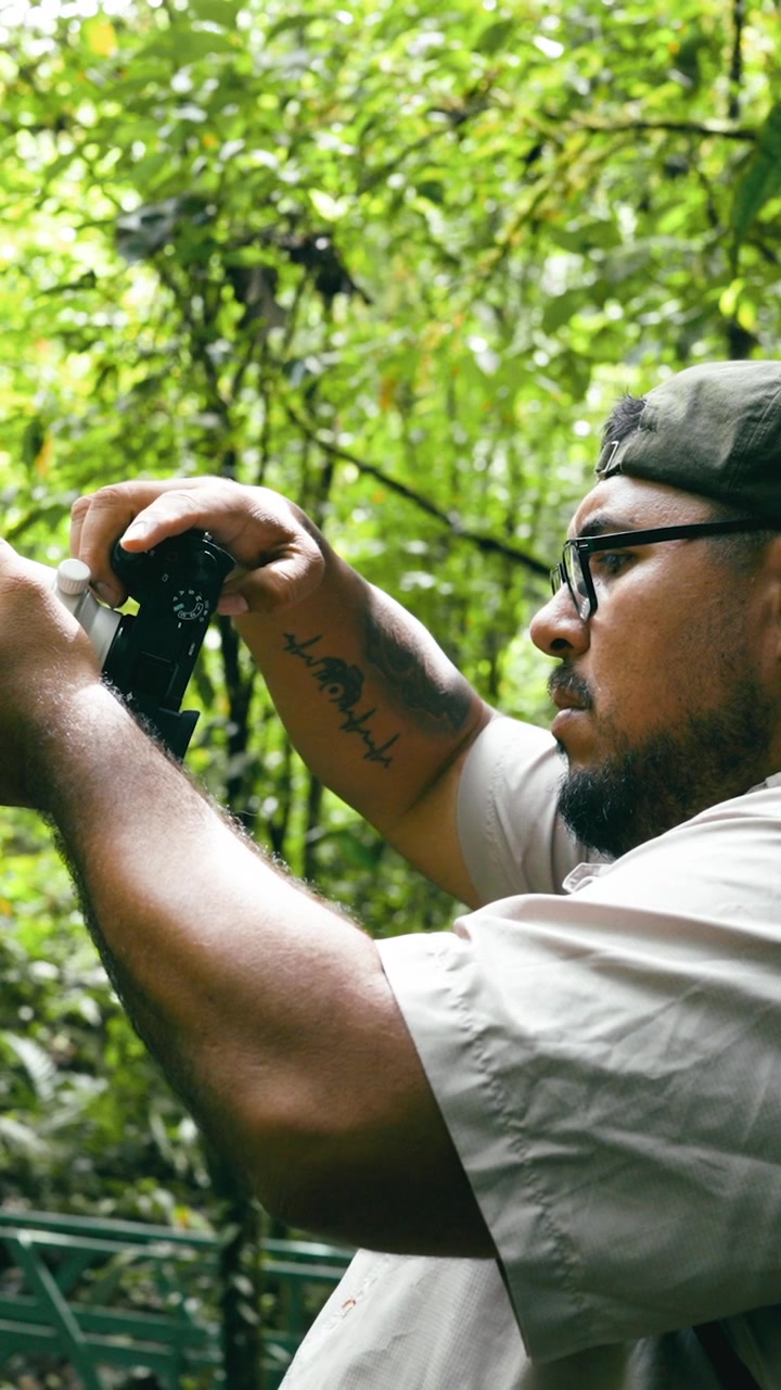 Fotografo che scatta foto in una lussureggiante foresta tropicale.