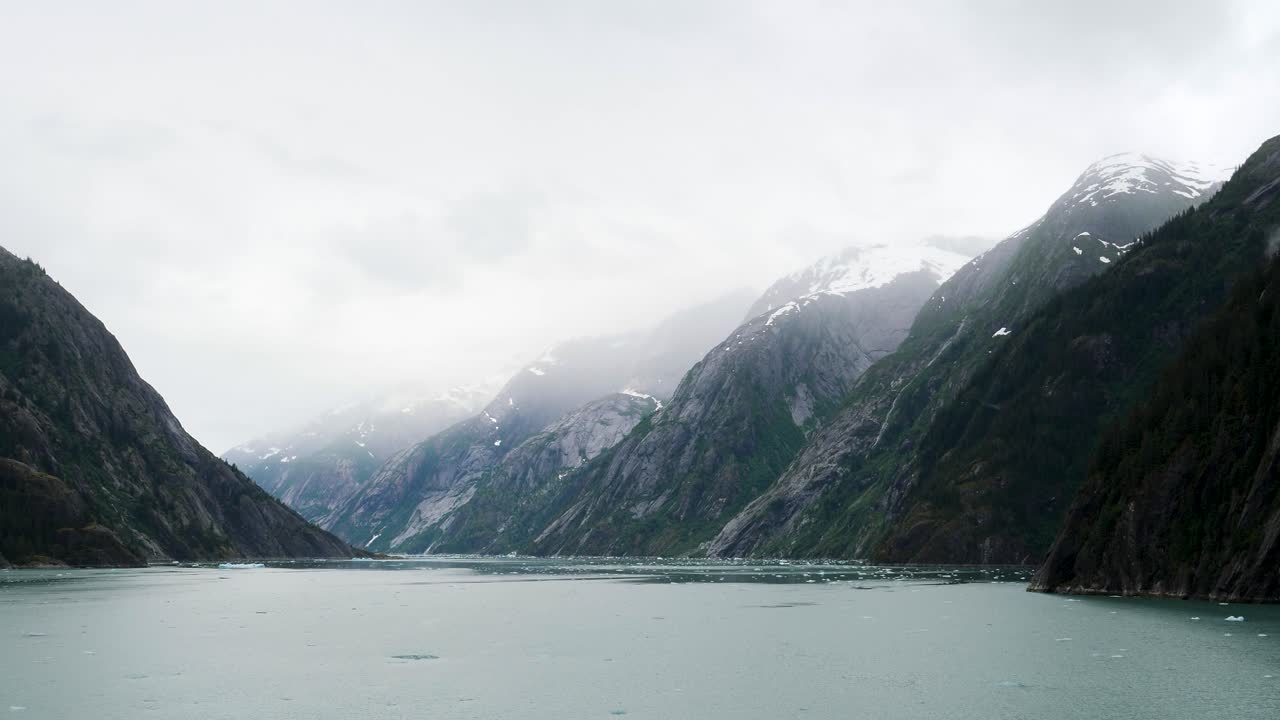 Endicott Arm fjord, Alaska.Otherworldly landscape with snow-capped mountains covered by thick fog.
