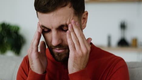 un joven se siente cansado en casa.