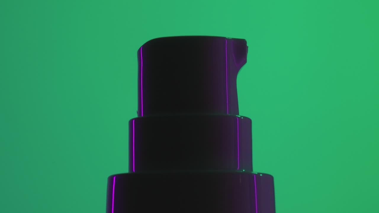 bote dosificador de crema cosmética girando sobre fondo verde