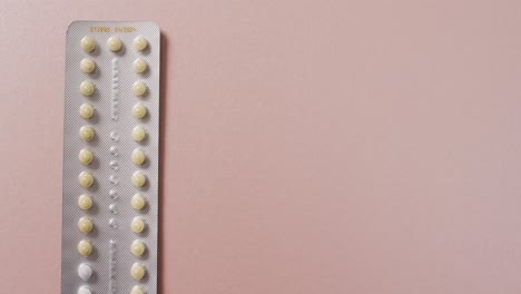 video of close up of yellow tablets on pink background