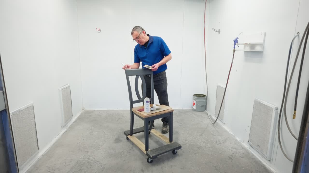 Uniformed worker adds precise brush touches as camera pushes in, supplies on seat