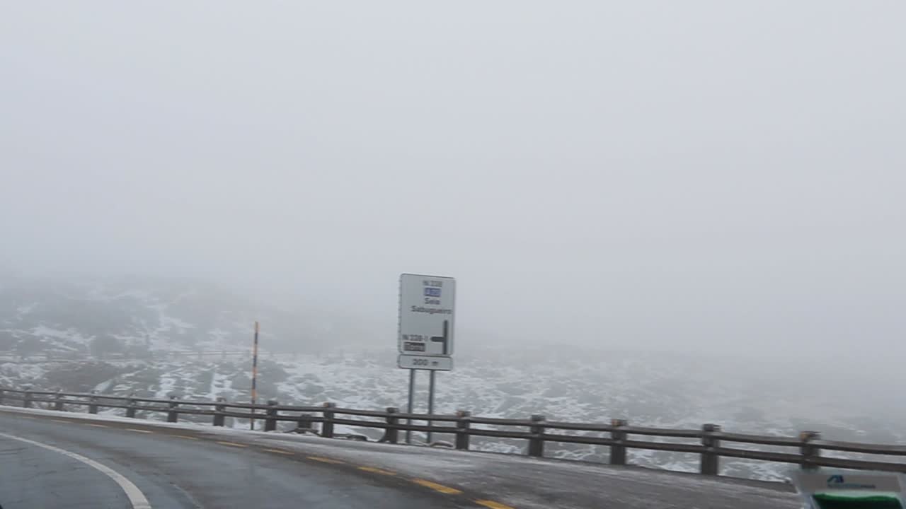 Driving on a  Wet Snowy Mountain Road Taking a Sharp Turn on a Foggy Day With Low Visibility