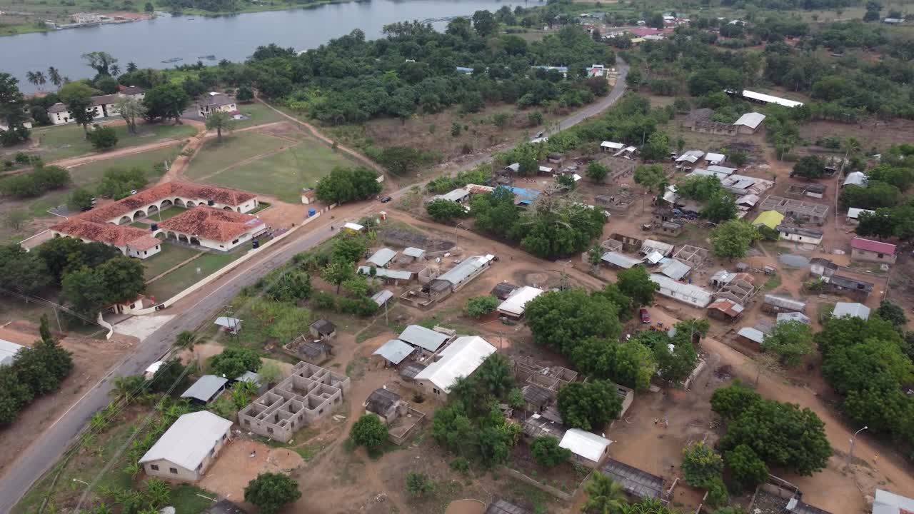Filmato aereo di un drone in Ghana, Africa, lago sereno, dolci montagne e paesaggio naturale. Barche sull'acqua. Un villaggio locale, vicino alla Right to Dream Football Academy.
