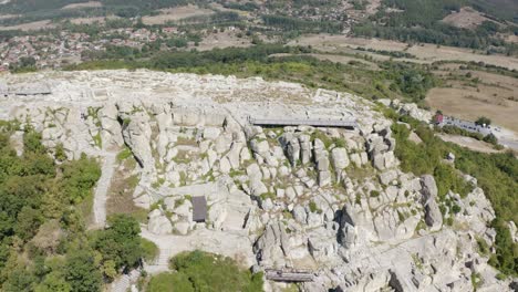 Zurückweichende-Drohnenaufnahme,-Die-Langsam-Nach-Rechts-Schwenkt-Und-Den-Gesamten-Abschnitt-Der-Antiken-Stadt-Perperikon-Zeigt,-Die-Auf-Einem-Hügel-In-Der-Provinz-Kardschali-In-Bulgarien-Liegt