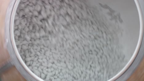 ver el interior de una gran tina giratoria de almendras azucaradas en la fábrica