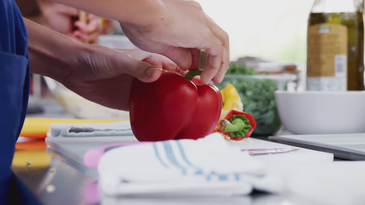 primer plano de una mujer cortando pimientos para el plato en la clase de cocina de la cocina