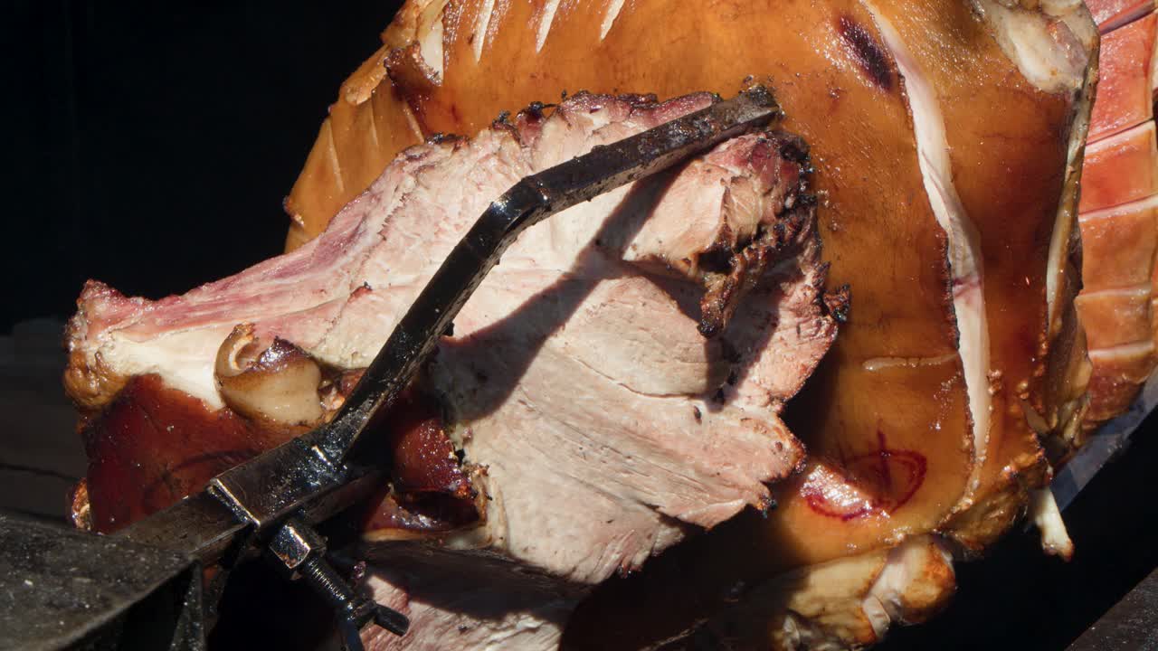 Whole pork roasting on spit over open flame, golden skin, classic Prague street food