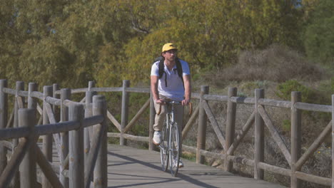 cyclist on a wooden path to the beach 1