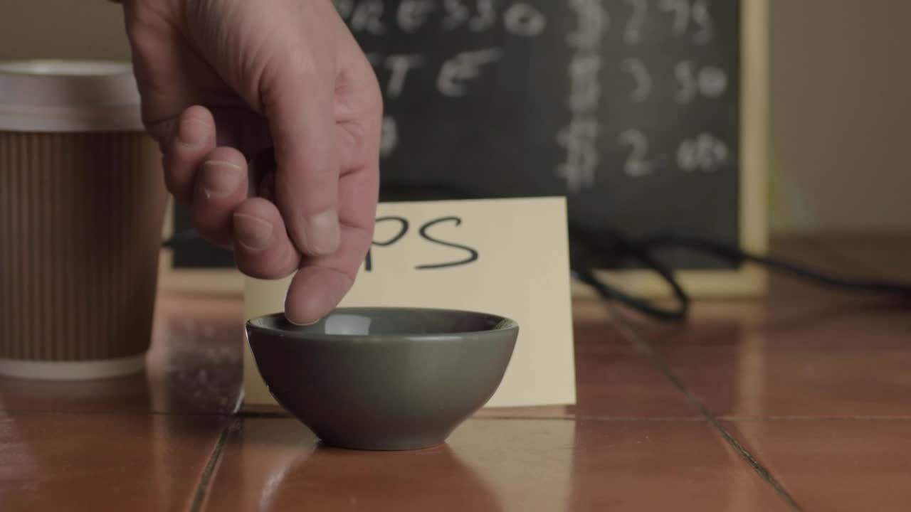 Hands putting coins in tip jar in cafe medium shot