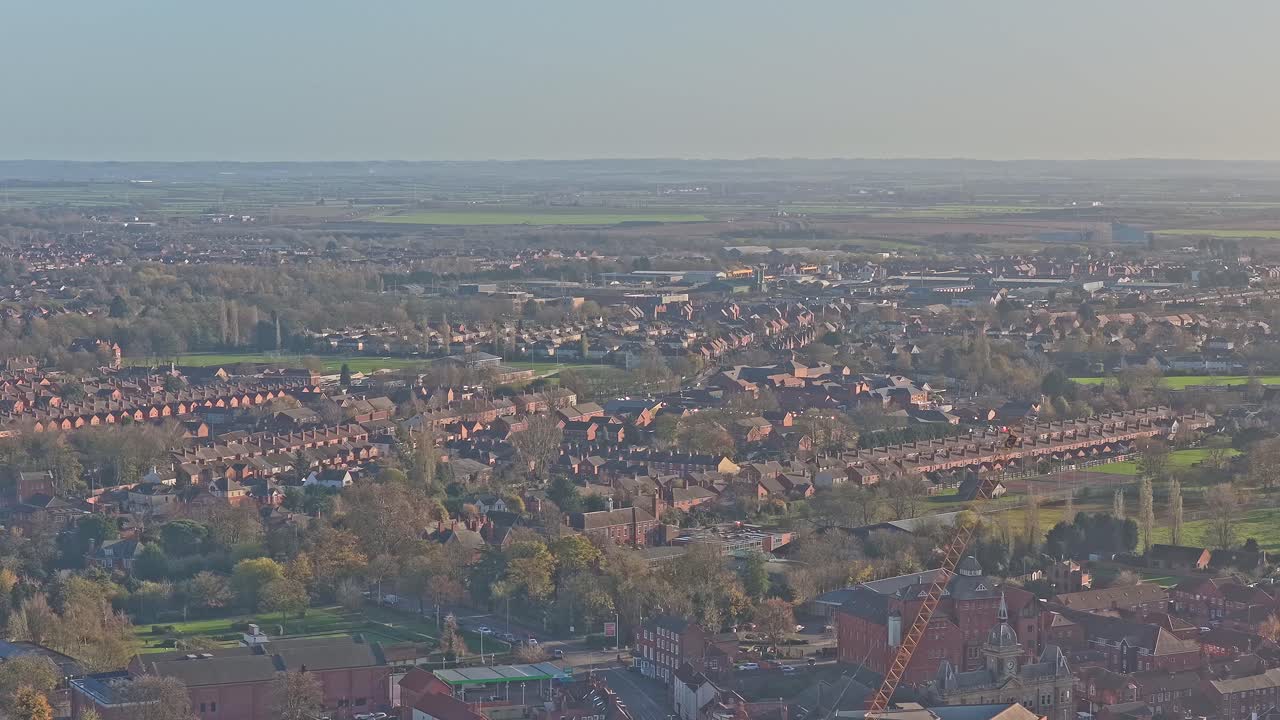 Paesaggio urbano di Newark-on-Trent che mostra tetti residenziali, case a schiera e strade, integrando spazi verdi e alberi, da una prospettiva aerea sulla storica città mercato