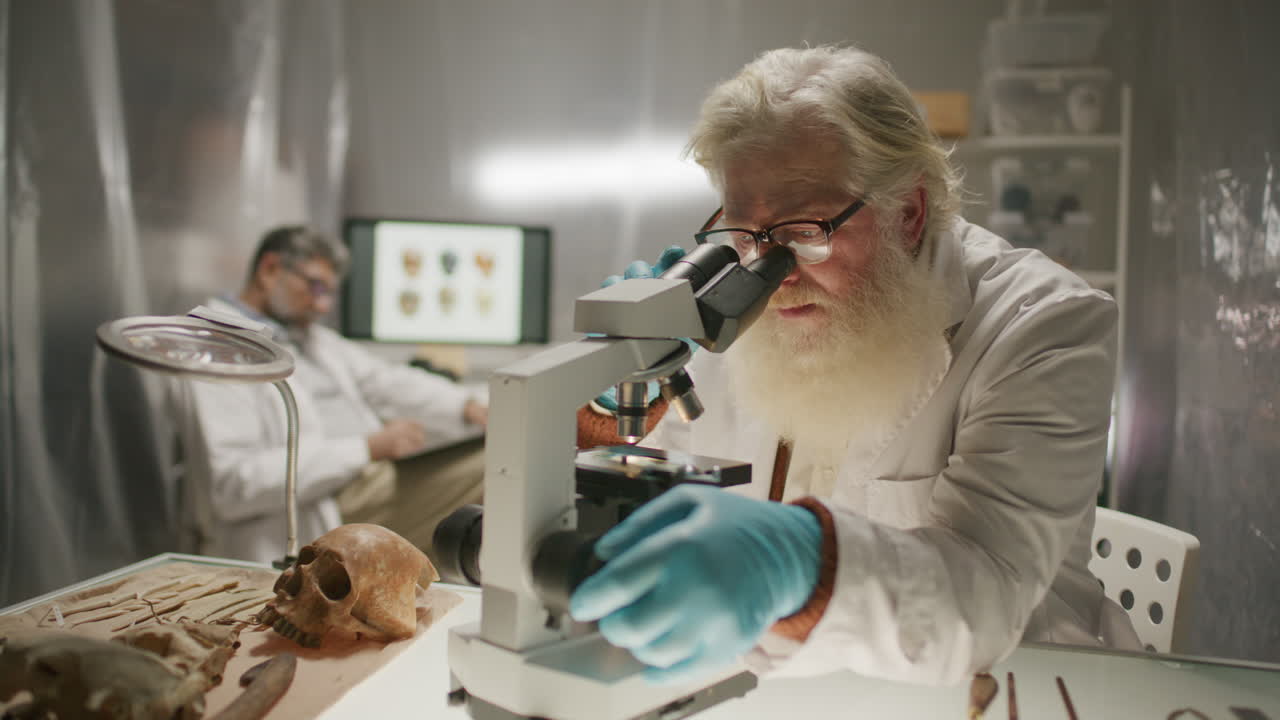 Elderly Archaeologist Analyzing Specimen through Microscope in Laboratory