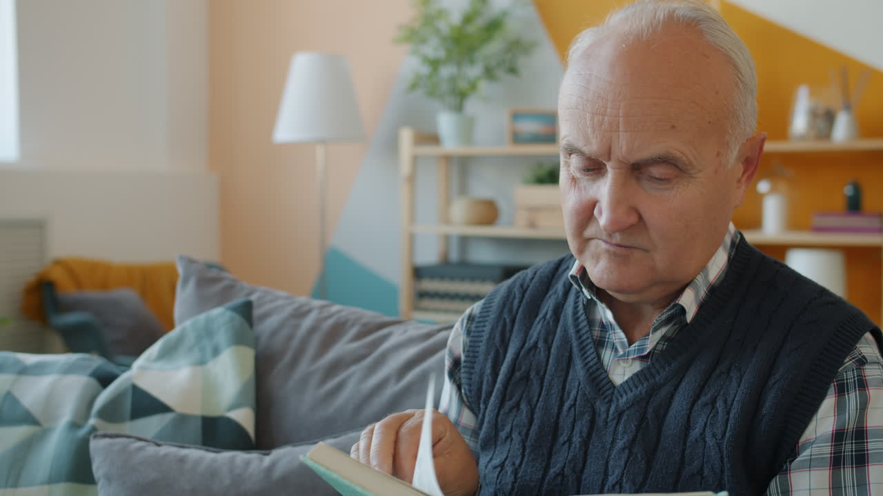 hombre mayor leyendo un libro en casa