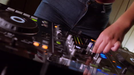 a mixer and turntables as a dj turns the knobs and dances in slow motion