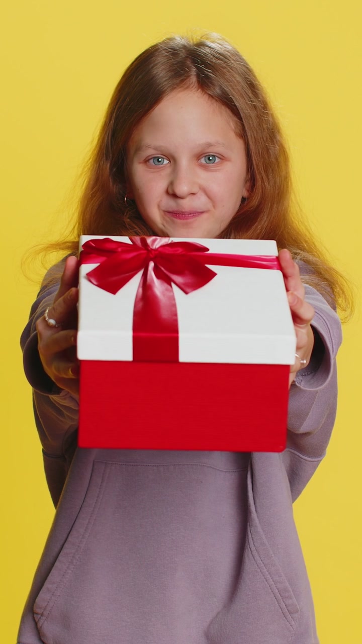 Bambina preadolescente sorridente bambina bambina che presenta una scatola di regali di compleanno offre un regalo avvolto per festeggiare
